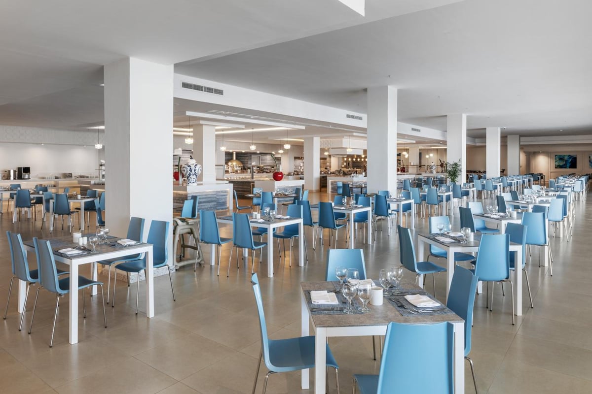 Albatros Makadi Resort restaurant dining room with blue chairs and white columns.