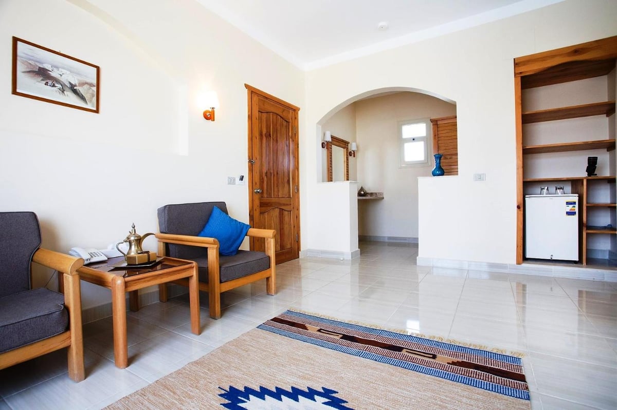 Sheikh Ali Dahab Resort sitting area with gray armchairs and an arched doorway.