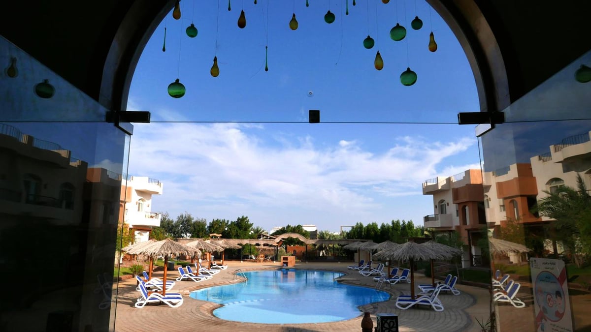 Sheikh Ali Dahab Resort pool courtyard with a swimming pool and lounge chairs.