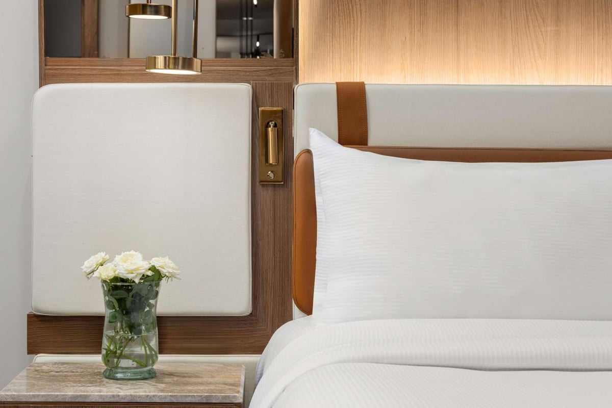Hilton Alexandria Green Plaza guest room bed with white bedding and a wood headboard.
