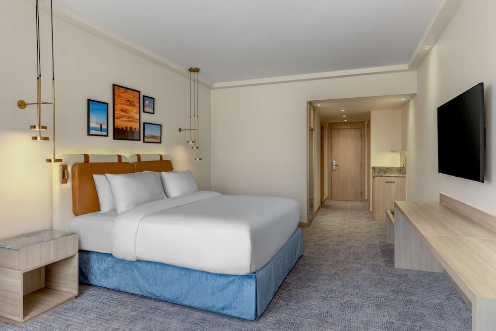 Hilton Alexandria Green Plaza guest room with a king bed and kitchenette.