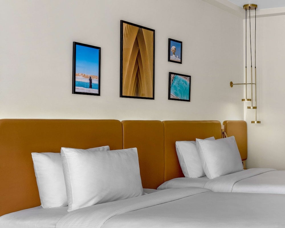 Hilton Alexandria Green Plaza guest room with twin beds and a mustard headboard.