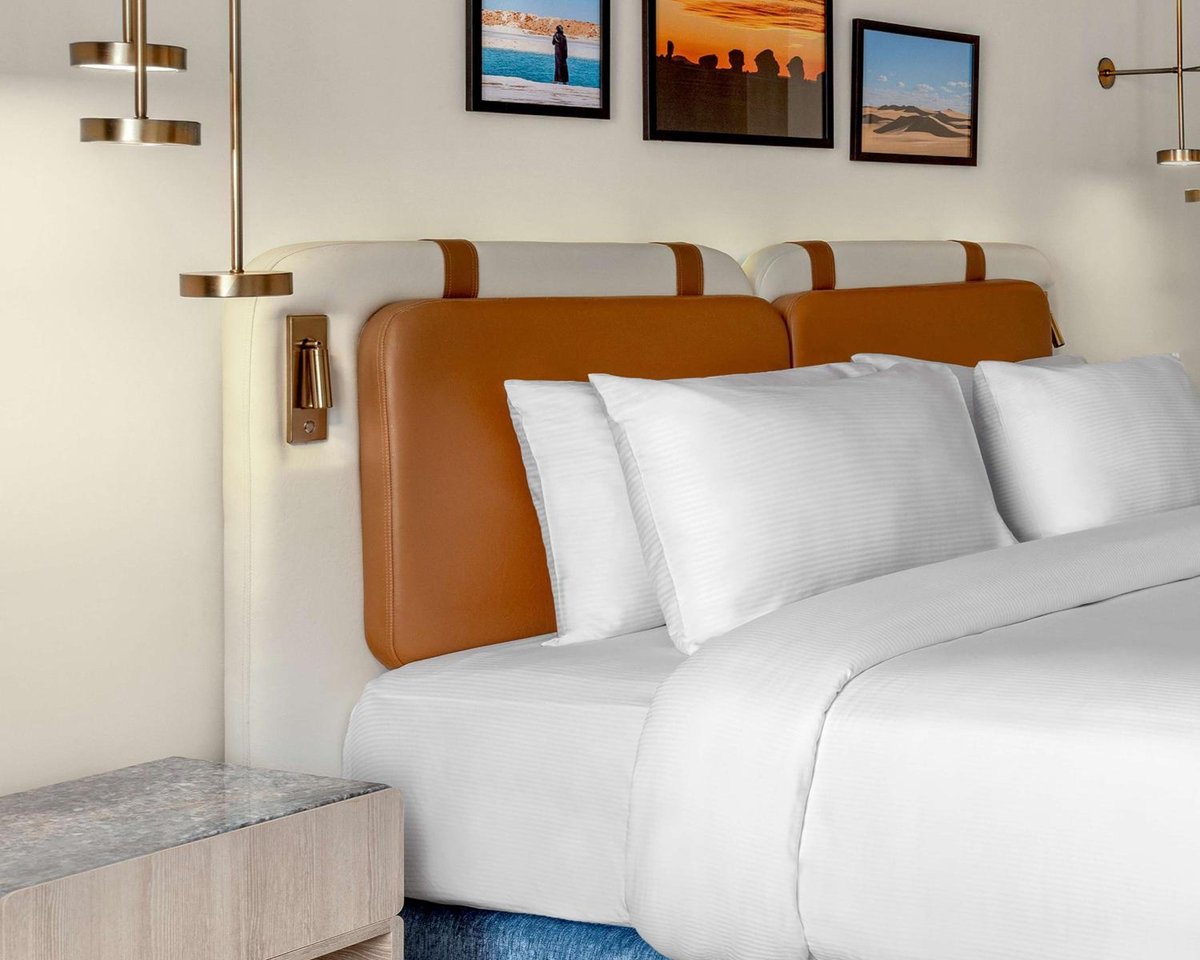 Hilton Alexandria Green Plaza bedroom with white bedding and upholstered headboards.