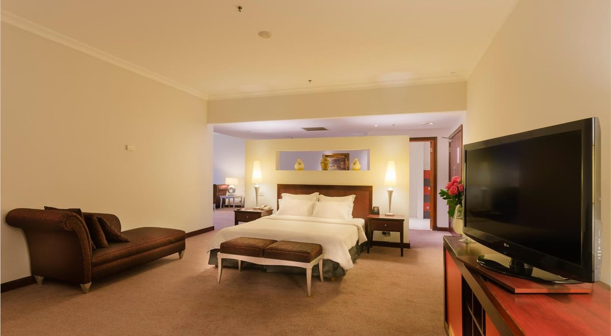 Hilton Alexandria Green Plaza guest room with a bed and a sofa.