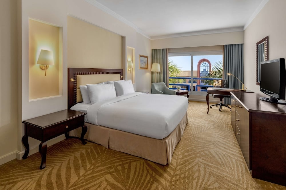 Hilton Alexandria Green Plaza guest room with a large bed and a work desk.