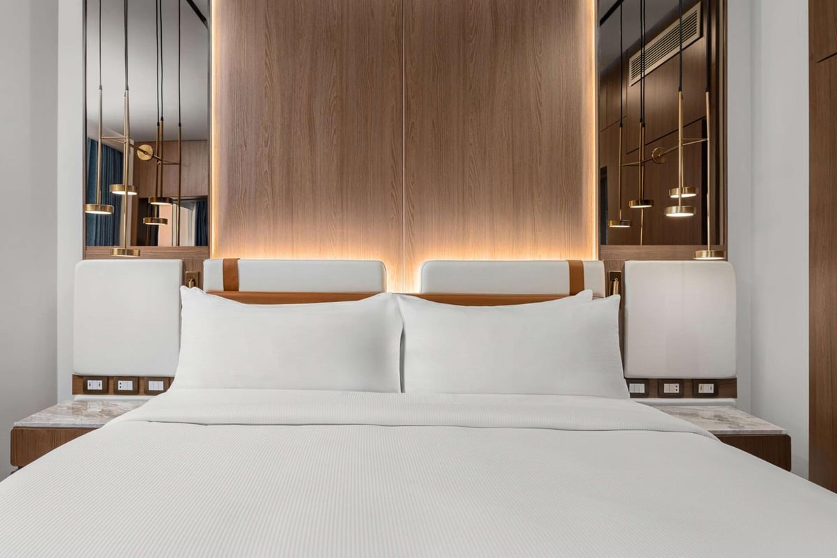 Hilton Alexandria Green Plaza guest room with white bedding and a wood headboard.