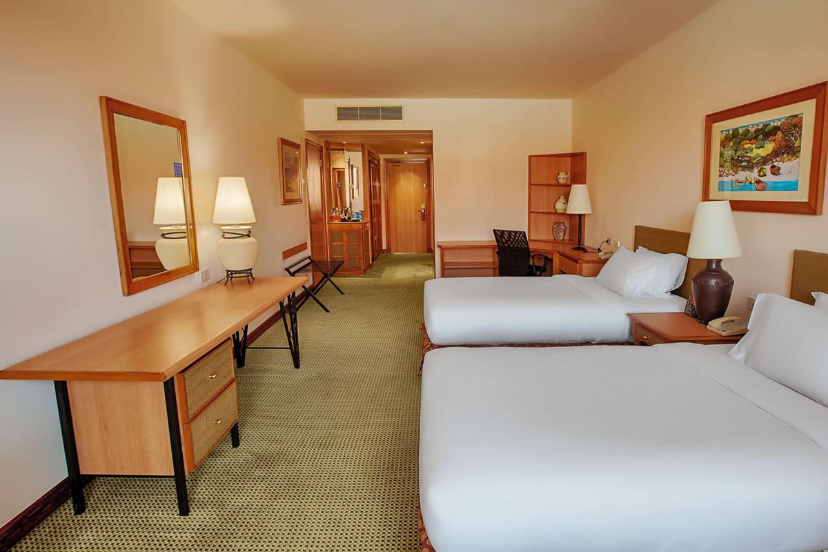 Hilton Alexandria Green Plaza guest room with twin beds and a work desk.
