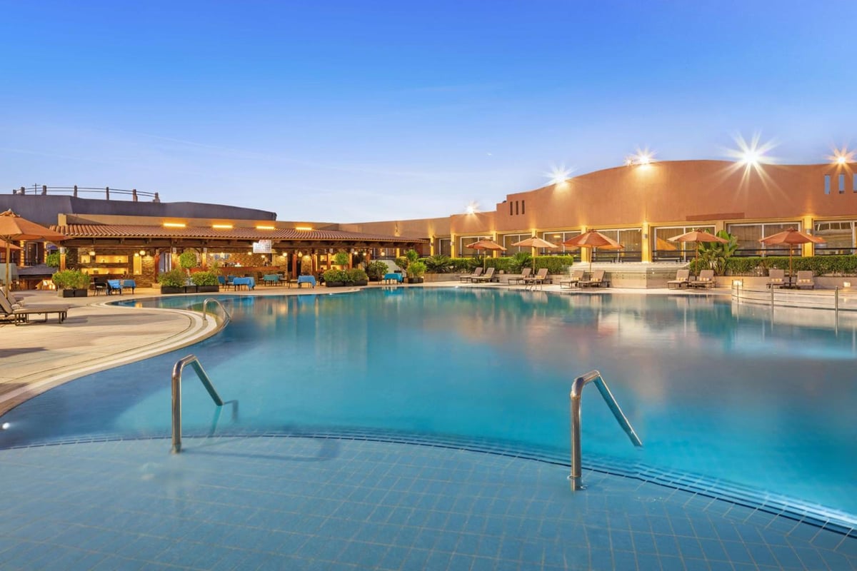 Hilton Alexandria Green Plaza outdoor pool with blue water and a curved tiled edge.