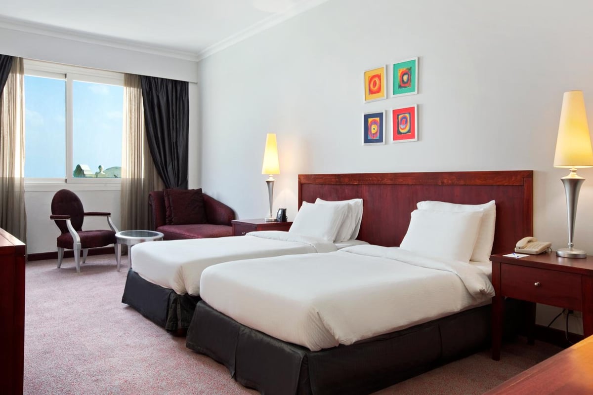 Hilton Alexandria Green Plaza twin bedroom with two beds and a large window.