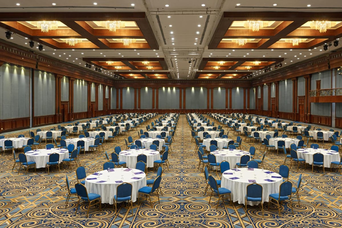 Hilton Alexandria Green Plaza ballroom with round tables and chandeliers.