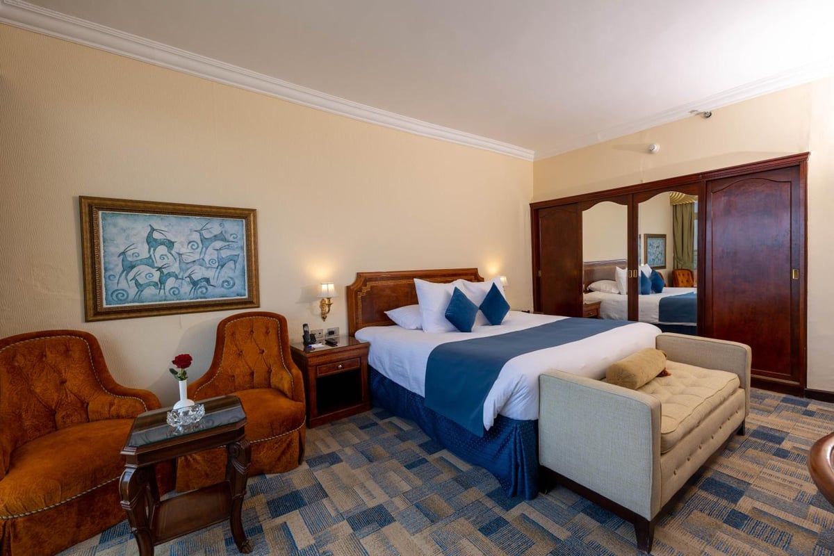 Palestine Montaza Alexandria guest room with a blue-and-white bed and mirrored wardrobe.