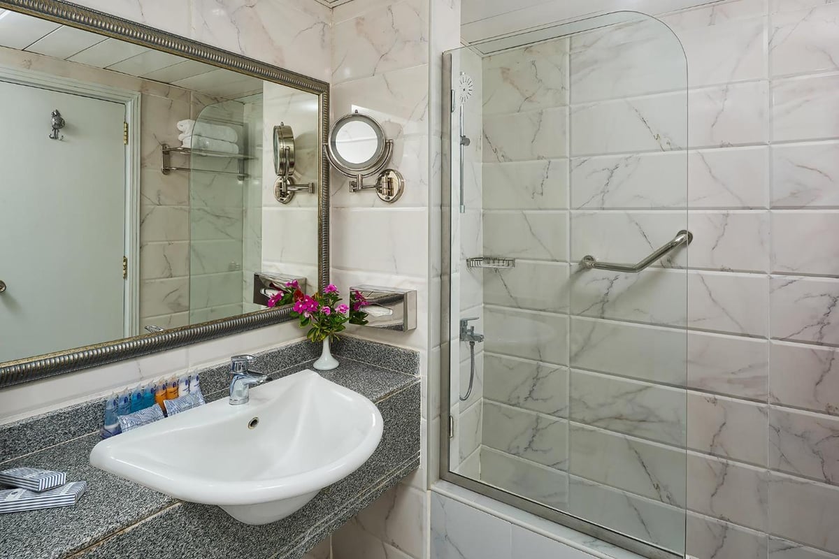 Dreams Vacation - Sharm El Sheikh bathroom with granite countertop and glass shower enclosure.
