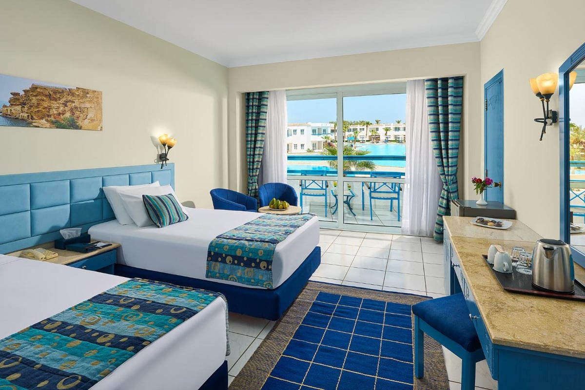 Dreams Vacation - Sharm El Sheikh twin room with two beds and a balcony overlooking the pool.