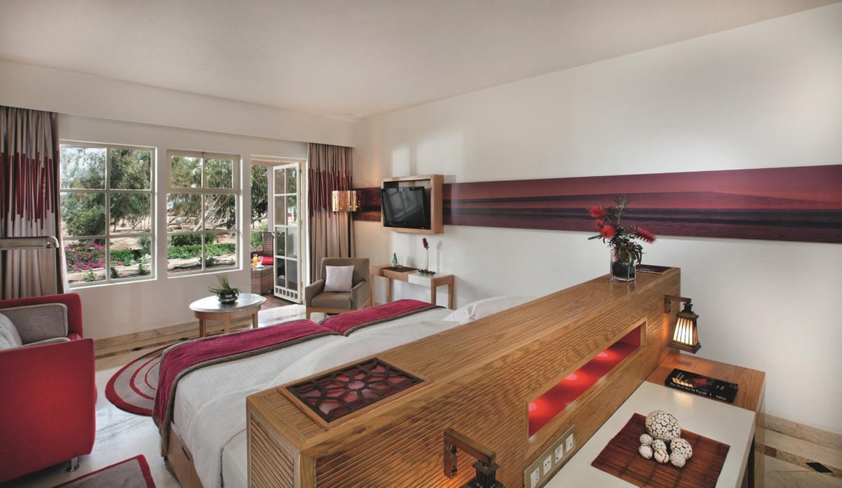 Movenpick Resort & Spa El Gouna guest room with a bed and sitting area.