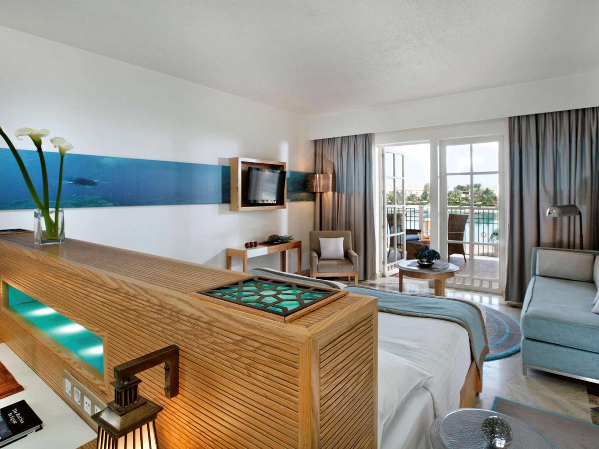 Movenpick Resort & Spa El Gouna guest room with a bed and balcony doors.