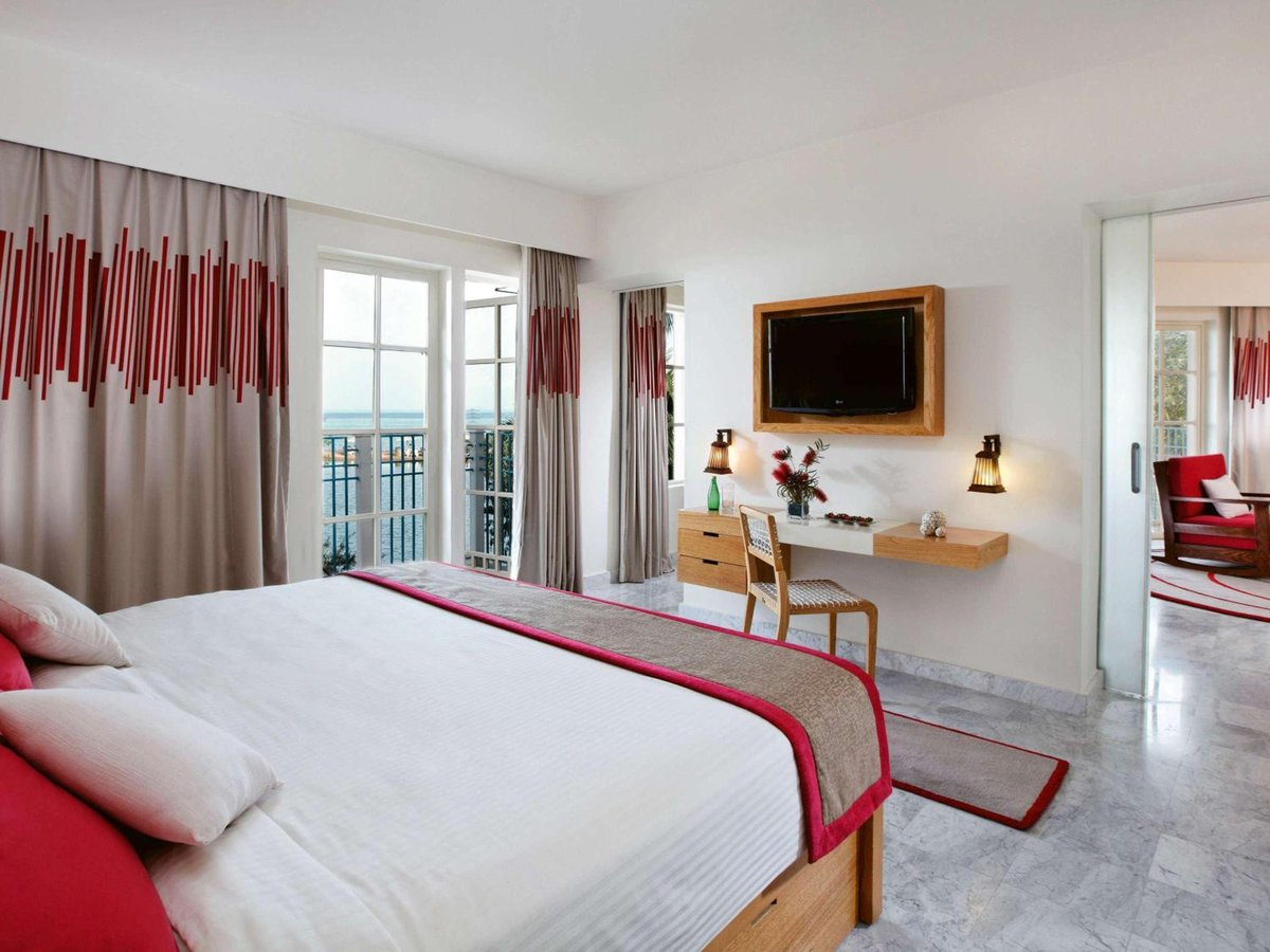 Movenpick Resort & Spa El Gouna guest bedroom with a white bed and balcony doors.