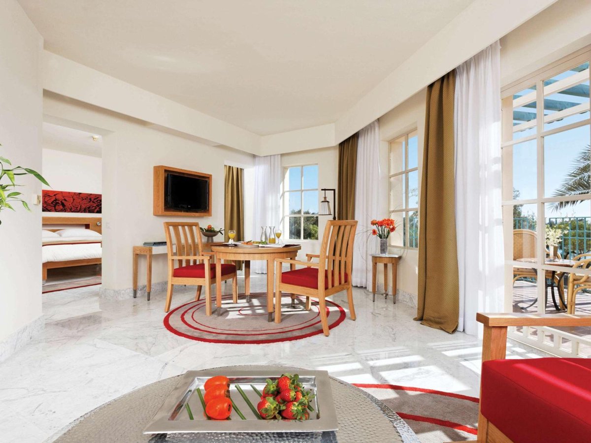 Movenpick Resort & Spa El Gouna dining area with a round table and tall windows.