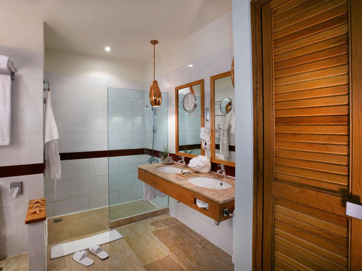 Movenpick Resort & Spa El Gouna bathroom with a glass shower and wooden vanity.