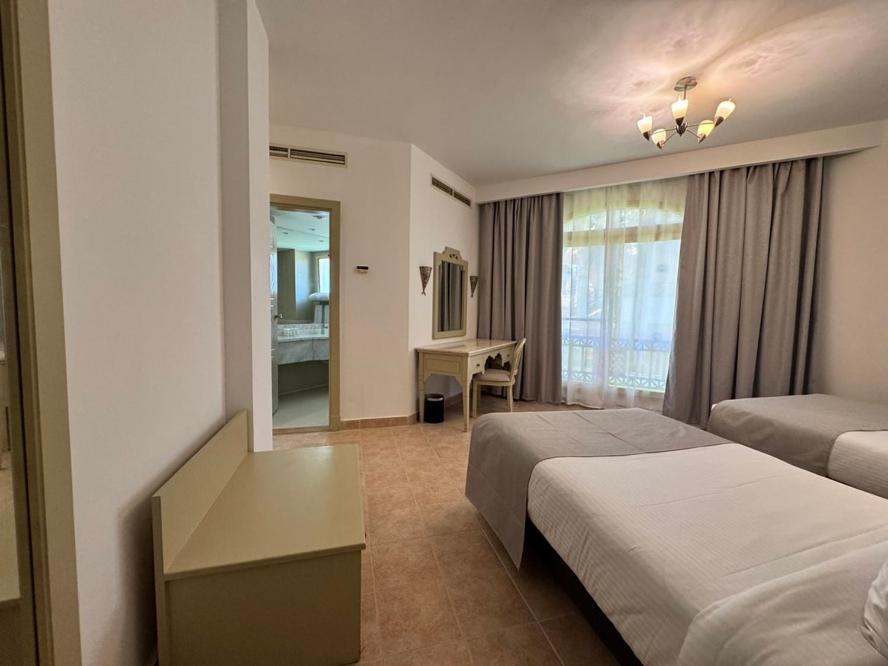 Amphoras Beach Ultra All Inclusive twin room with two beds and a curtained window.