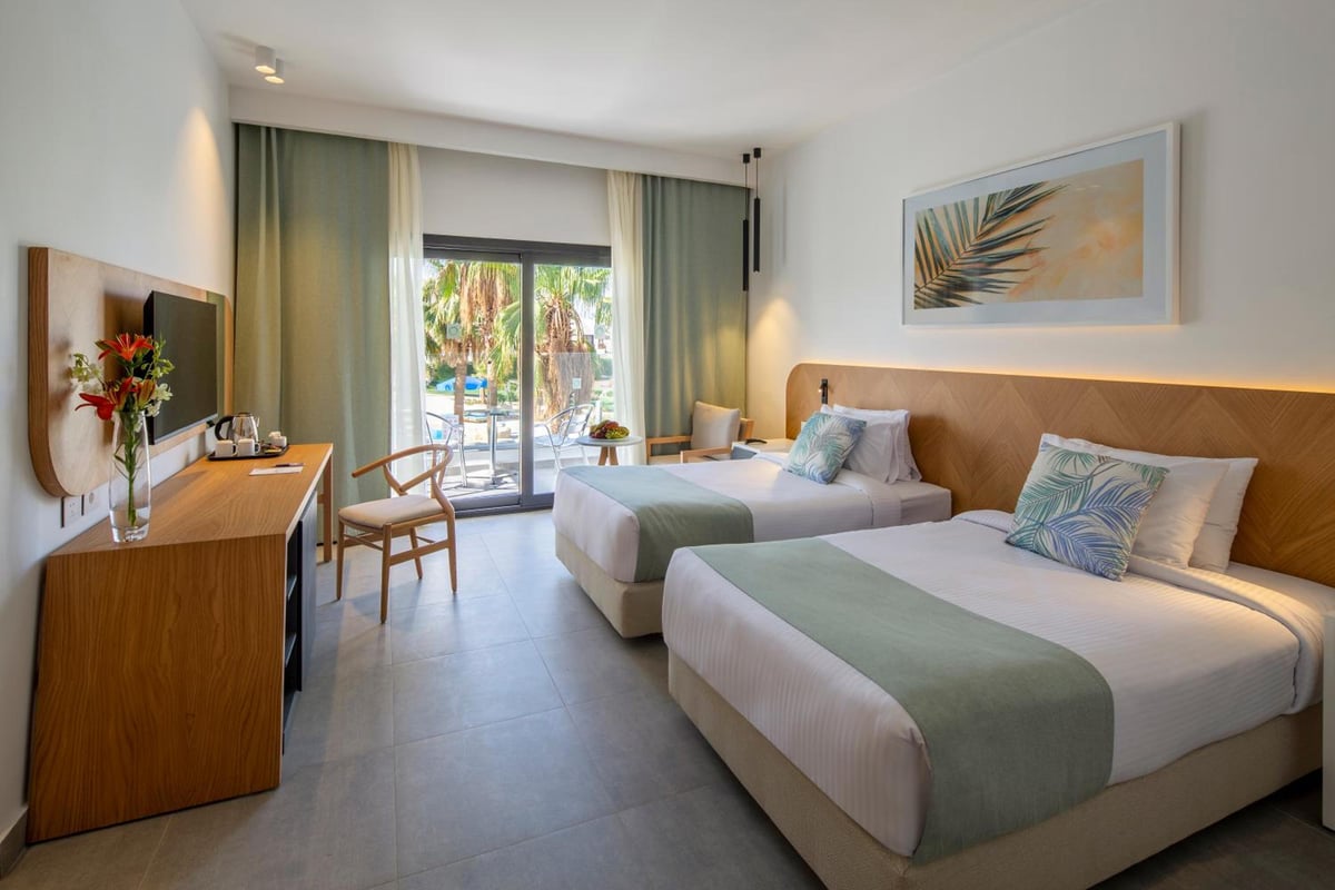 Amphoras Beach Ultra All Inclusive guest room with twin beds and sliding glass doors.