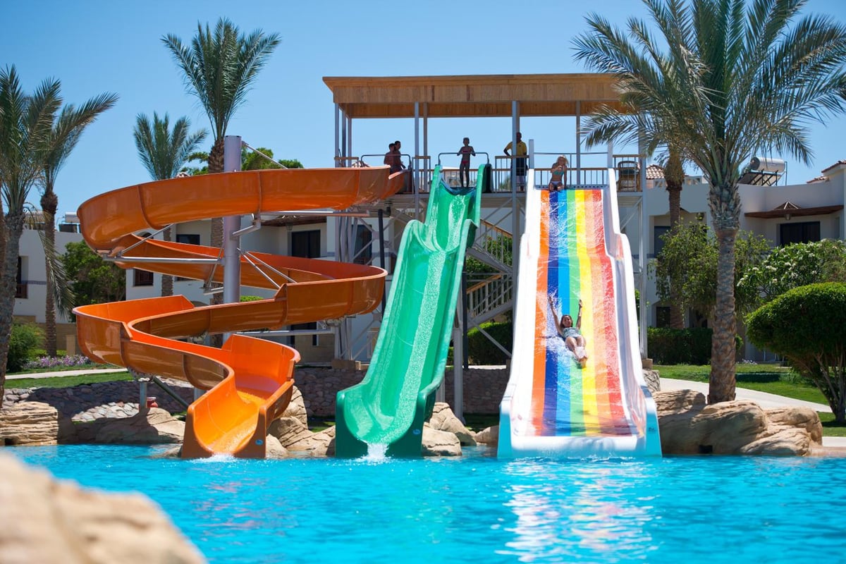 Amphoras Beach Ultra All Inclusive water slides with an orange spiral slide and a rainbow slide.