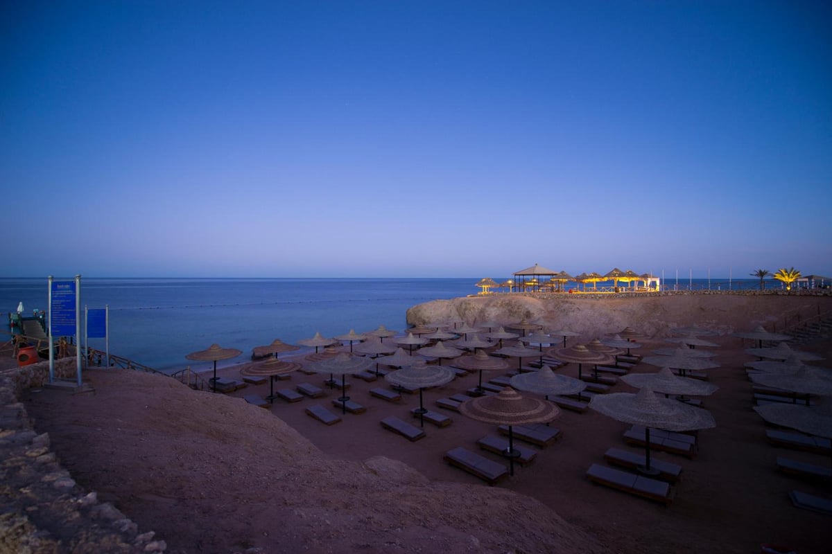 Amphoras Beach Ultra All Inclusive beach with rows of loungers and thatched parasols.