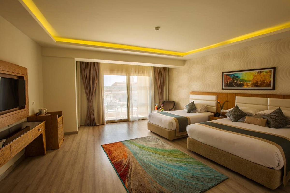 Pickalbatros Aqua Blu Sharm El Sheikh guest room with two beds and sliding balcony doors.