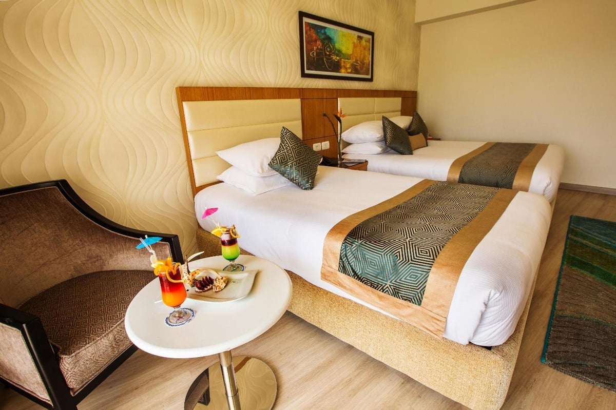 Pickalbatros Aqua Blu Sharm El Sheikh twin bedroom with two beds and a textured wall.