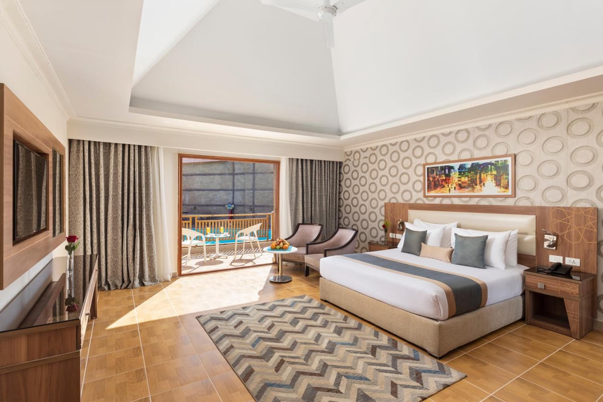 Pickalbatros Aqua Blu Sharm El Sheikh guest room with a bed and sliding balcony doors.