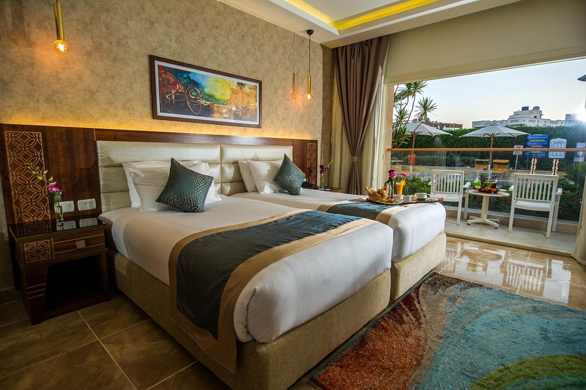Pickalbatros Aqua Blu Sharm El Sheikh guest bedroom with twin beds and a balcony.