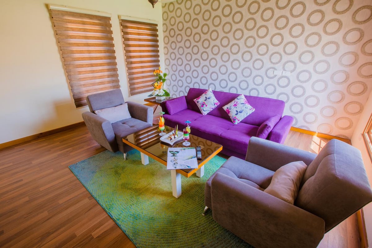 Pickalbatros Aqua Blu Sharm El Sheikh seating area with a purple sofa and patterned wallpaper.