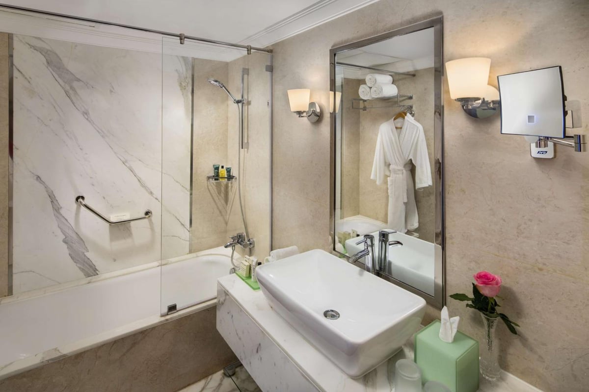 Hilton Alexandria Corniche bathroom with a bathtub and a glass shower screen.