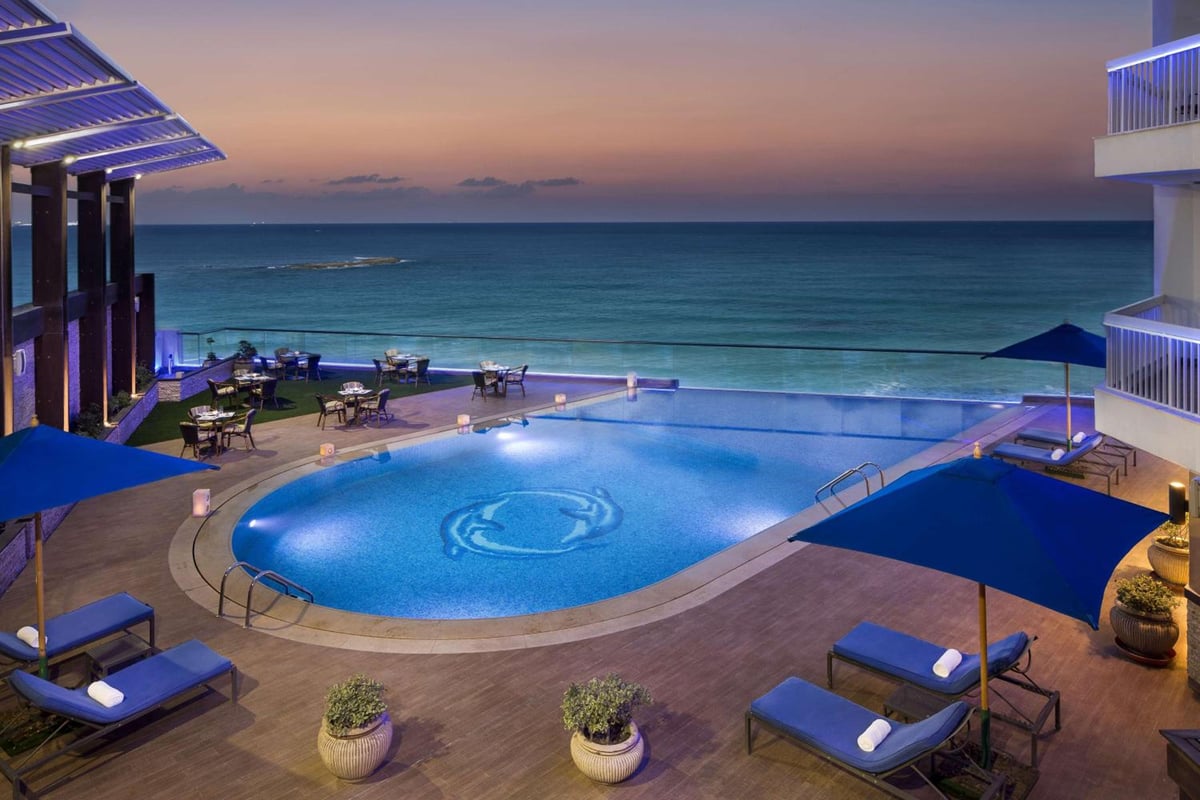 Hilton Alexandria Corniche pool deck with a curved pool and sea views.
