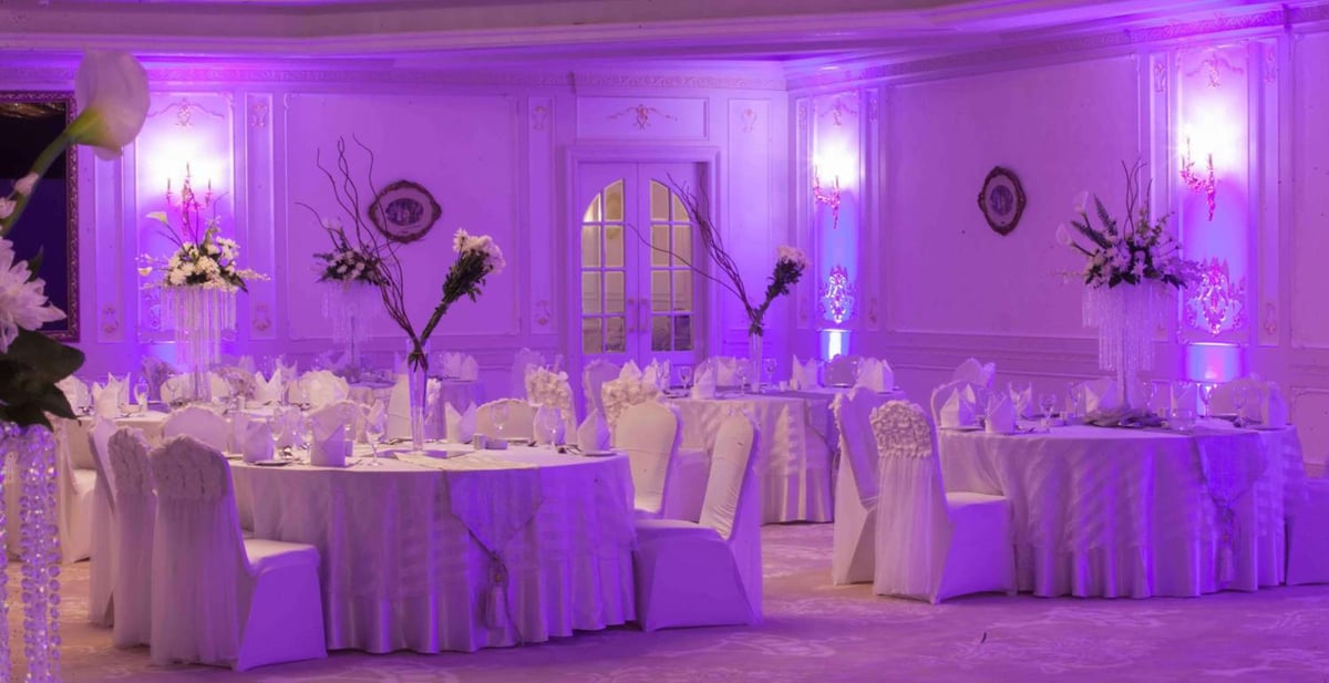 Hilton Alexandria Corniche ballroom with round tables and purple lighting.