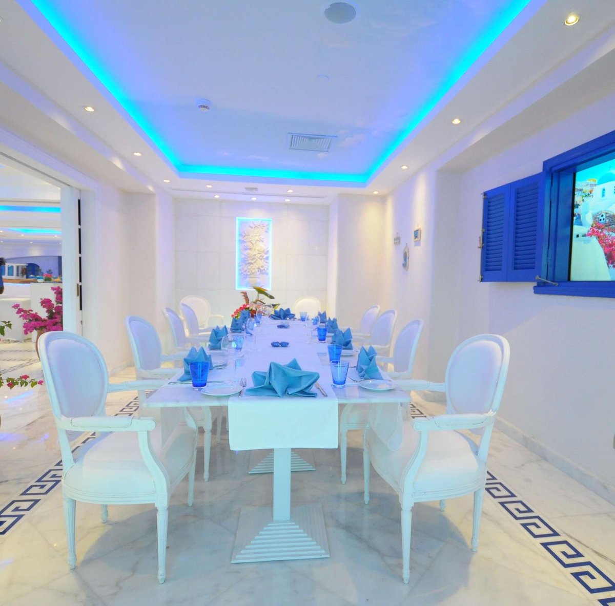 Hilton Alexandria Corniche dining room with a long table and blue ceiling lighting.