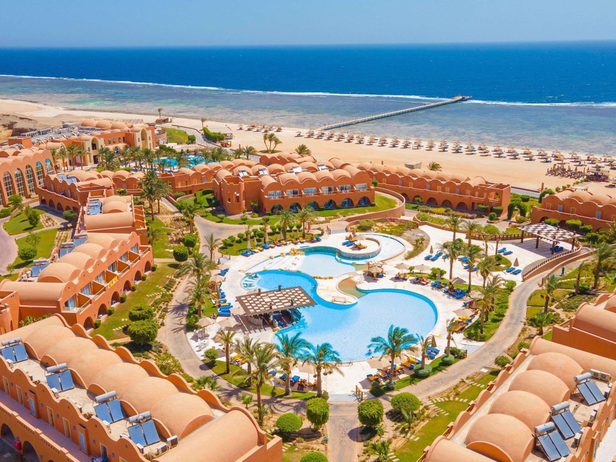 Novotel Marsa Alam Beach Resort pool area with curving pools and palm trees.