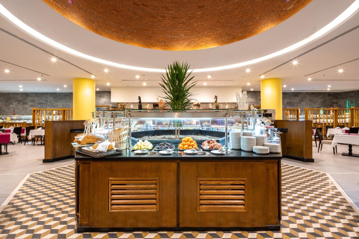 Novotel Marsa Alam Beach Resort buffet restaurant with a glass display counter and patterned tile floor.