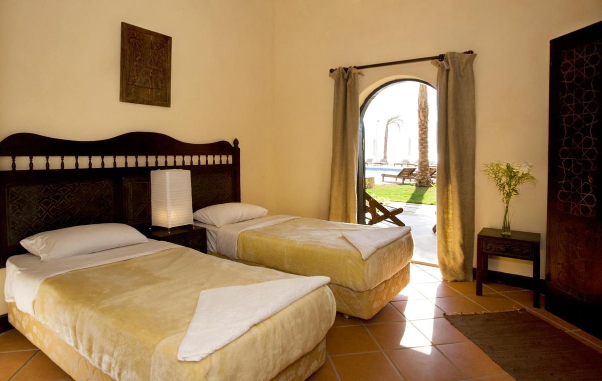 Dahab Paradise twin bedroom with two beds and an arched doorway.