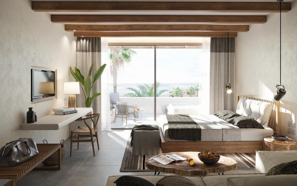 JAZ Elite Riviera bedroom with exposed ceiling beams and a balcony overlooking the sea.