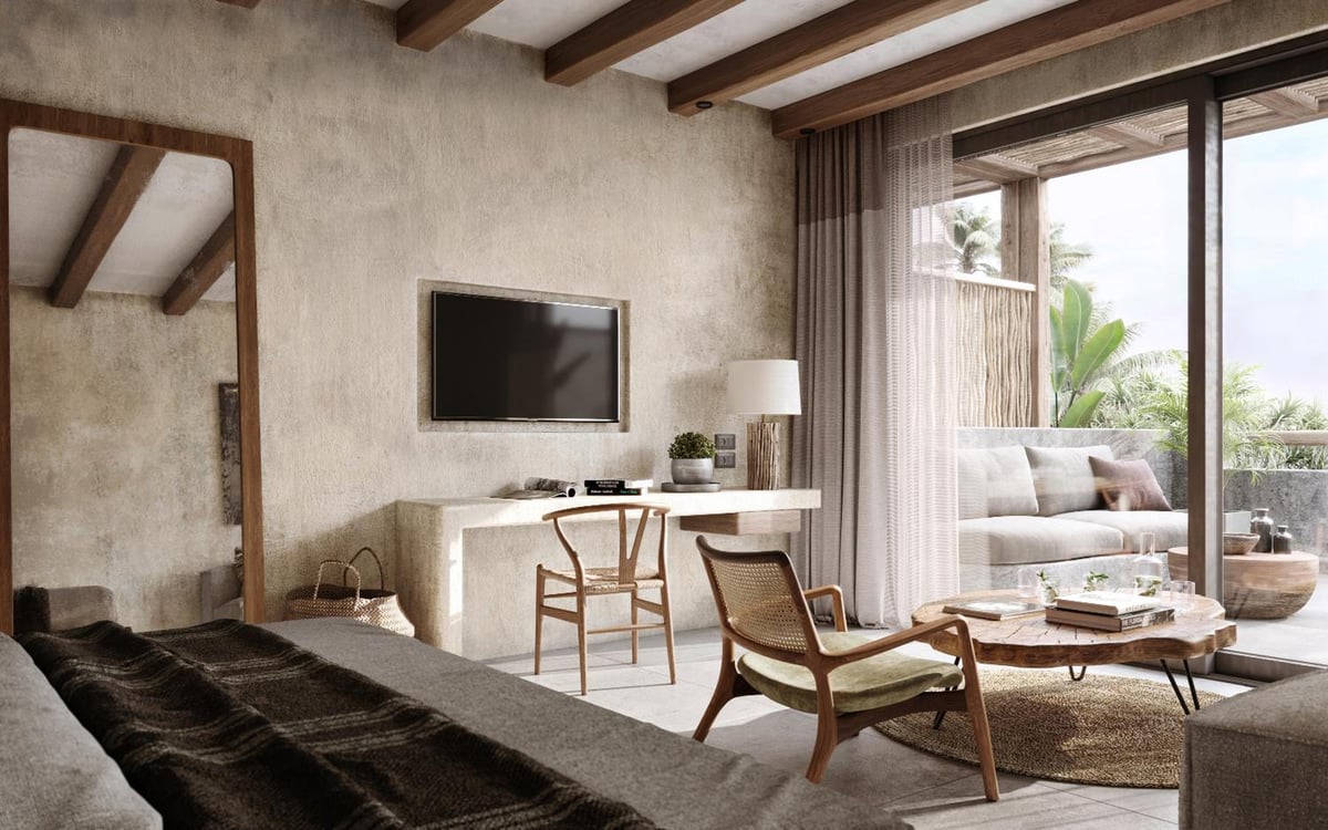 JAZ Elite Riviera guest room with a bed and a sitting area.