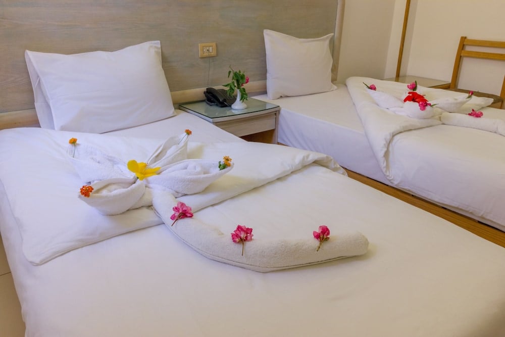 Acacia Dahab Hotel twin room with two beds and floral towel arrangements.