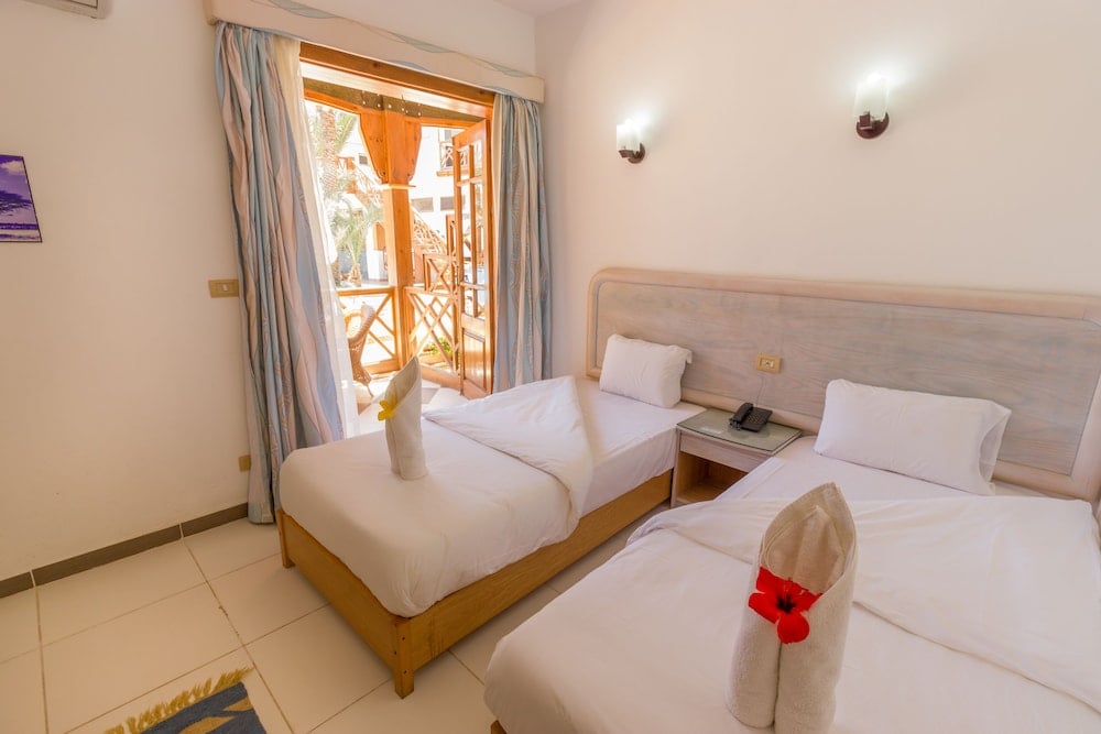 Acacia Dahab Hotel twin bedroom with two beds and balcony doors.