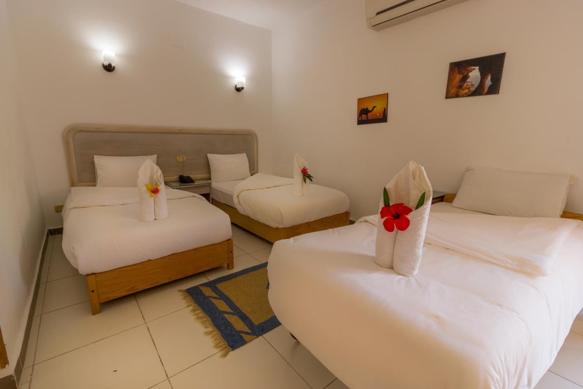 Acacia Dahab Hotel guest room with three beds and a tiled floor.