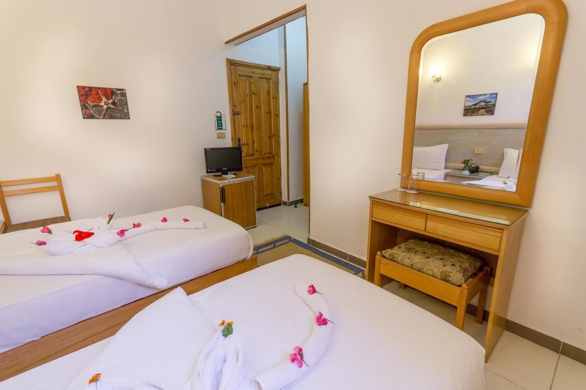 Acacia Dahab Hotel twin bedroom with two beds and a large framed mirror.