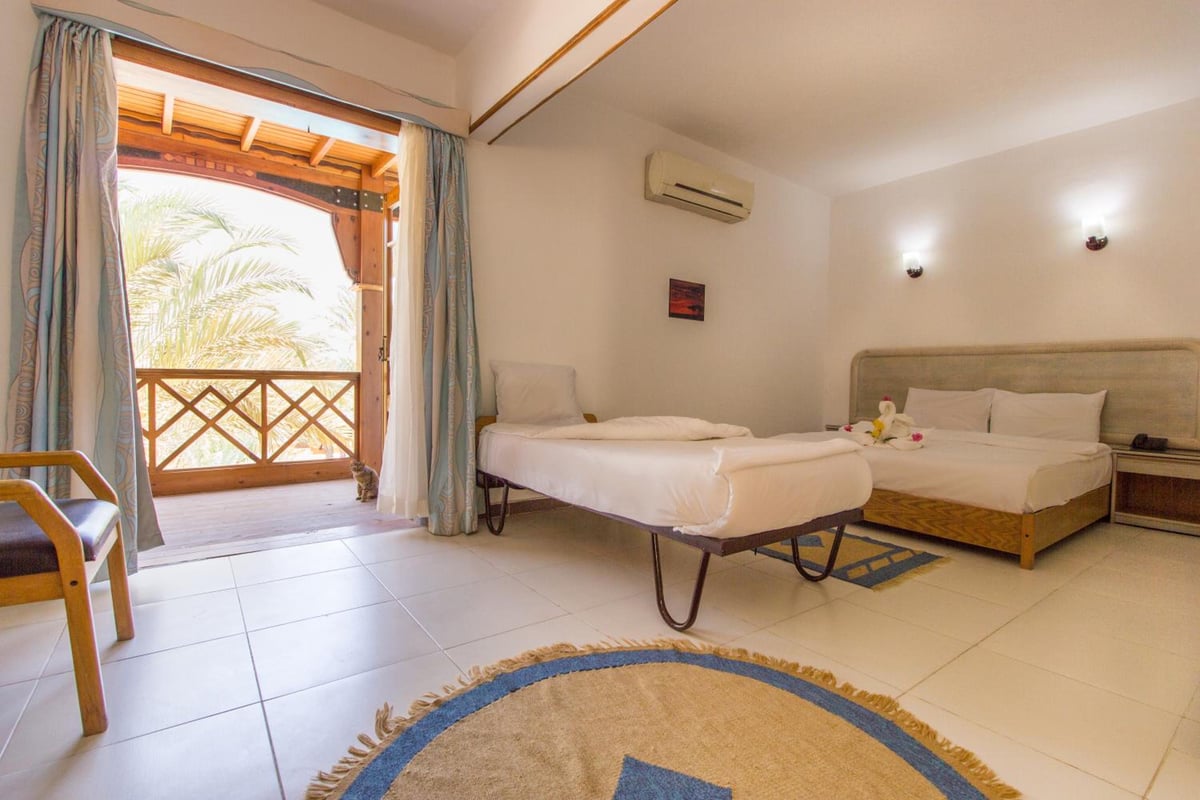 Acacia Dahab Hotel guest room with two beds and a balcony doorway.