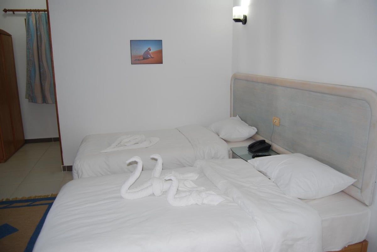 Acacia Dahab Hotel twin bedroom with two beds and a padded headboard.