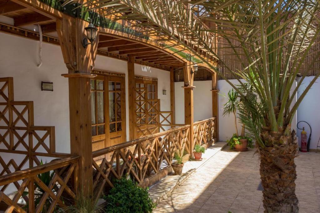 Acacia Dahab Hotel covered walkway with wooden lattice railings and a slatted timber roof.