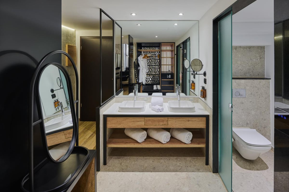 Steigenberger Aldau Beach Hotel bathroom with twin basins and open shelving.