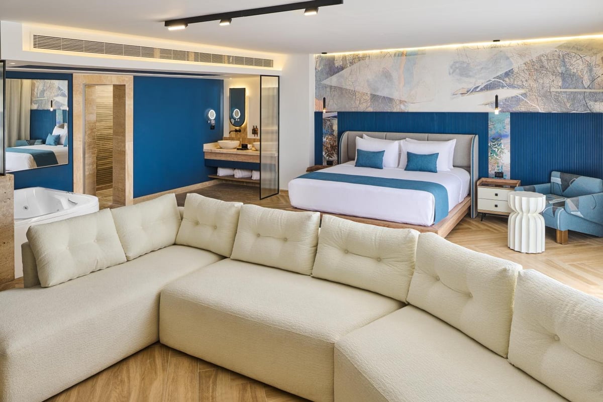 Steigenberger Aldau Beach Hotel suite with a sectional sofa and king bed.