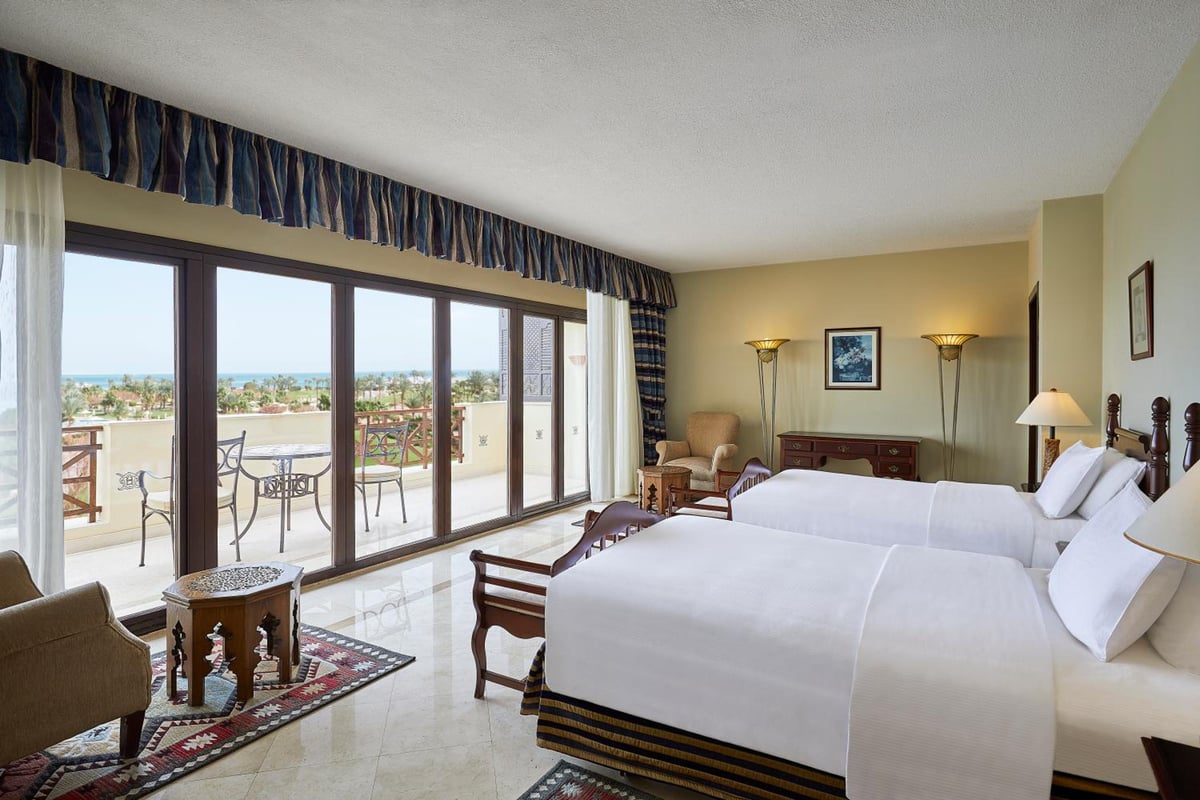 Steigenberger Aldau Beach Hotel guest room with two beds and sliding glass doors.
